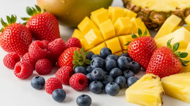 Een bord met verse aardbeien, mango, frambozen, ananas en bosbessen.