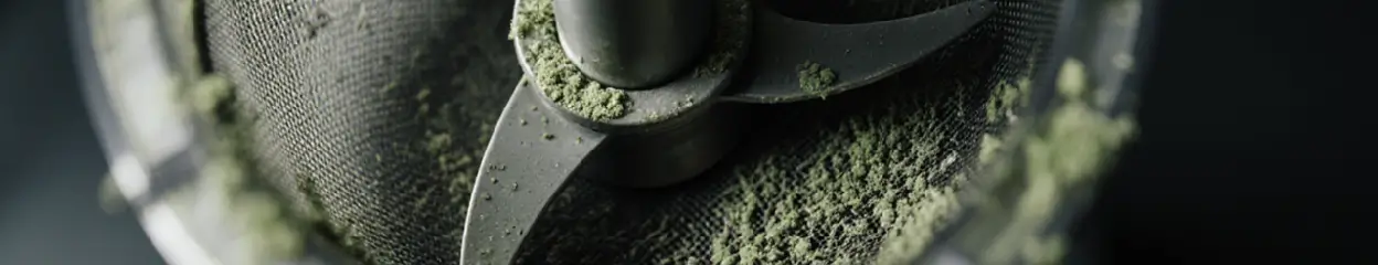 Een close-up van het mes en de zeef van een vieze sapcentrifuge.