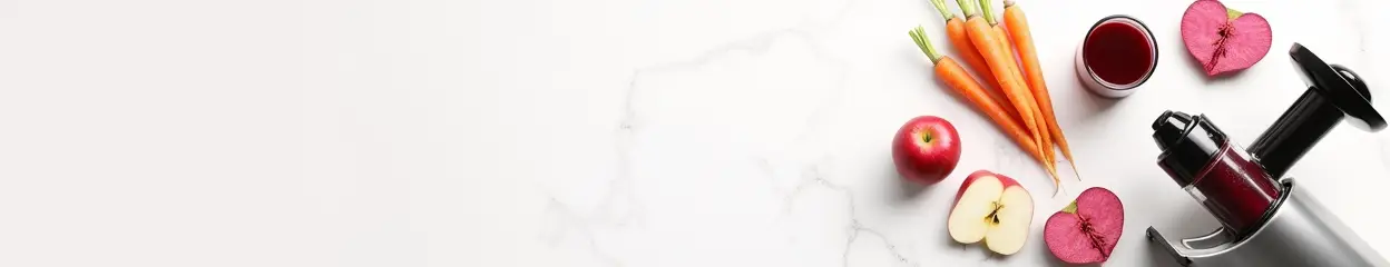 Juicer met harde groente en fruit op marmeren blad.